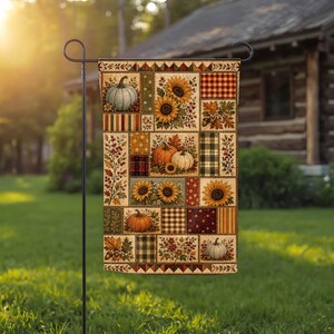 May include: A rectangular garden flag featuring a patchwork design of autumn-themed patterns. The print includes illustrations of orange and white pumpkins, yellow sunflowers, red berries, acorns, and various plaid and checkered fabric textures.