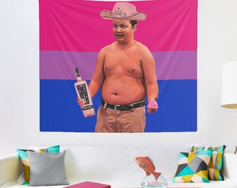 Puede incluir: Un hombre con un sombrero de vaquero rosa y una botella de licor en la mano se encuentra frente a una bandera del orgullo bisexual.