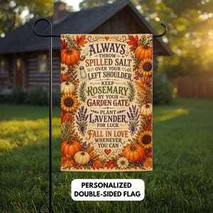 May include: A rectangular garden flag featuring a cream background with a border of orange pumpkins, sunflowers, and autumn leaves. The text reads: Always throw spilled salt over your left shoulder, keep rosemary by your garden gate, plant lavender for luck, fall in love whenever you can.