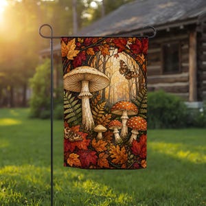 May include: A rectangular garden flag featuring a stained-glass style illustration of a forest scene with a large beige mushroom, several smaller red-capped mushrooms, green ferns, fallen autumn leaves in shades of red and orange, and butterflies.