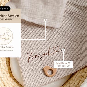 May include: A beige baby blanket with the name "Konrad" embroidered in a cursive font. The blanket has a ribbed texture and a wooden bird-shaped teether. The image also includes text that says "Summer Version" and "Breathable Muslin".