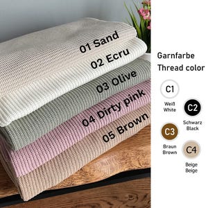 May include: A selection of knitted fabric swatches in shades of sand, ecru, olive, dirty pink, and brown. The image displays thread colour options: white, black, brown, and beige, with corresponding colour codes.