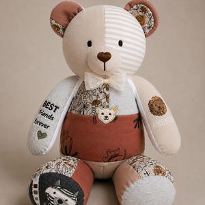 Könnte beinhalten: Ein Patchwork-Teddybär aus verschiedenen Stoffmustern in Braun-, Beige- und Grautönen. Der Bär hat eine cremefarbene Schleife am Hals, gestickten Text mit der Aufschrift "BEST friends forever" und "AWESOME" sowie einen kleinen bärenförmigen Aufnäher.