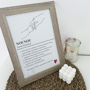 May include: A black and white line drawing of two hands holding each other. The text below the drawing defines the word "Nounou" as a noun, meaning a person of trust chosen by parents to help a child grow. The text also describes the qualities of a "Nounou" as a caring, loving, and supportive person.