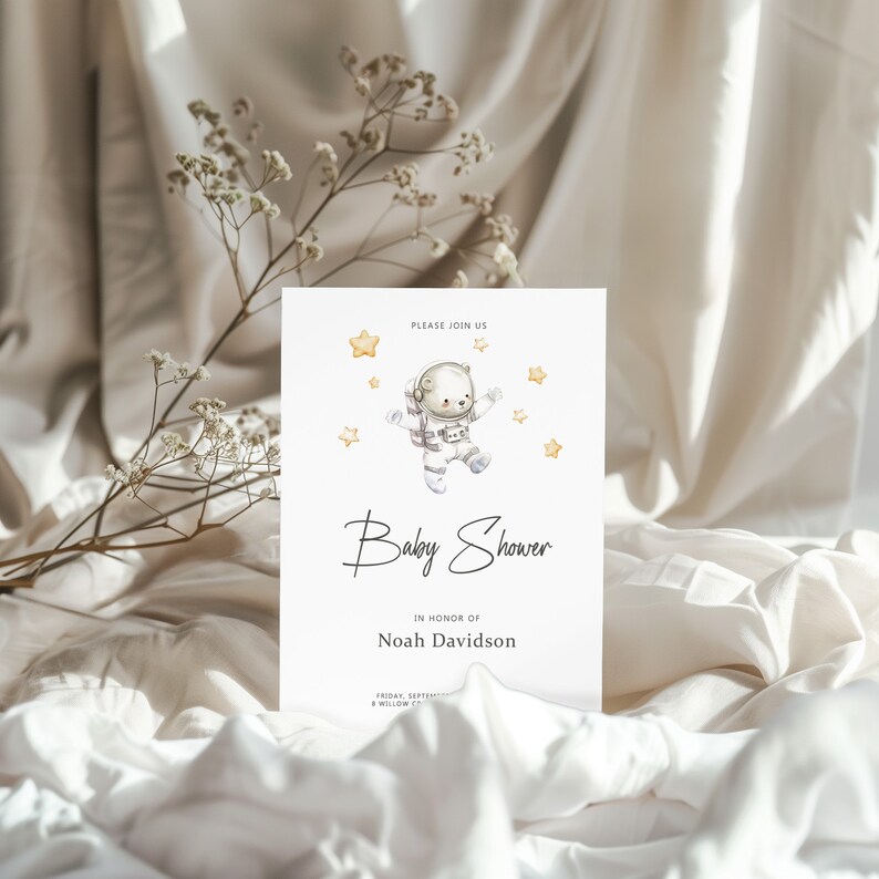 May include: A baby shower invitation with a cute illustration of a bear wearing an astronaut suit and floating in space with stars. The text reads "Please join us Baby Shower in honor of Noah Davidson".