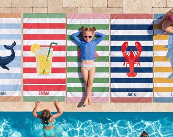 May include: Five rectangular beach towels with horizontal stripes, each featuring a unique graphic: a blue whale, a glass of lemonade, a solid green stripe, a red lobster, and a blue shark. Each towel includes a name printed at the bottom.