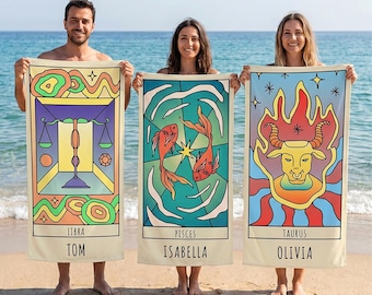 May include: A collection of rectangular beach towels featuring colorful, graphic illustrations of zodiac signs including Sagittarius, Aquarius, Scorpio, Taurus, Cancer, Capricorn, Libra, Pisces, Gemini, Aries, and Leo, each with a name printed below.