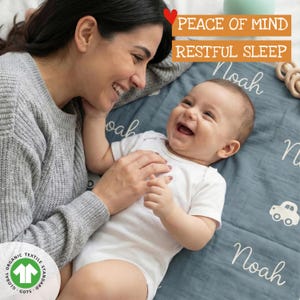 A smiling woman lies on a blue blanket with a baby named Noah, both appearing happy and content.