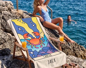 May include: A rectangular beach towel featuring a graphic illustration of a crab, a yellow and blue sky with stars, and geometric shapes. The word CANCER is printed in black capital letters above the name JACK, also in black capital letters.
