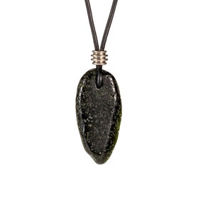 May include: A dark green, oval-shaped pendant with a black leather cord and silver metal accents. The pendant has a textured surface with small bubbles.