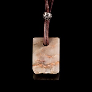 Può includere: Una collana in corda di cuoio marrone con un perno d'argento e un ciondolo rettangolare in pietra marmorizzata marrone chiaro e bianco.