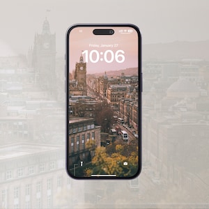 May include: A smartphone displaying a city skyline with a clock reading 10:06. The date is Friday, January 27. The phone is black with a silver frame.