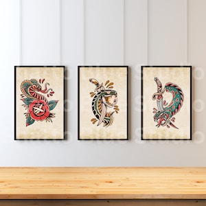 Puede incluir: Tres impresiones enmarcadas con ilustraciones de serpientes en estilo de tatuaje vintage. La primera impresión presenta una serpiente verde envuelta alrededor de una rosa roja. La segunda impresión presenta una serpiente verde con una daga atravesándola. La tercera impresión presenta una serpiente verde y azul con una daga atravesándola.
