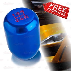 May include: A shiny blue gear shift knob with red gear pattern numbers. The numbers 1, 3, 5, 2, 4, and R are visible. The knob is cylindrical and has a reflective surface.