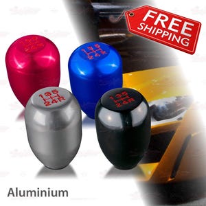 May include: Four aluminum shift knobs in red, blue, silver, and black. Each knob has a gear shift pattern in red. The word "Aluminium" is at the bottom of the image.