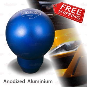 May include: A blue anodized aluminum shift knob with the "momo" logo and arrow. The shift knob is spherical with a cylindrical base. The text "Anodized Aluminium" is at the bottom of the image.