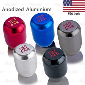 May include: Anodized aluminum shift knobs in red, blue, silver, black, and gray. Each knob has a gear shift pattern in red. The text "Anodized Aluminium" is at the top of the image.