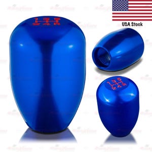 May include: A set of three blue car shift knobs. The knobs have a glossy finish and red text indicating the gear positions. The USA stock flag is in the upper right corner.