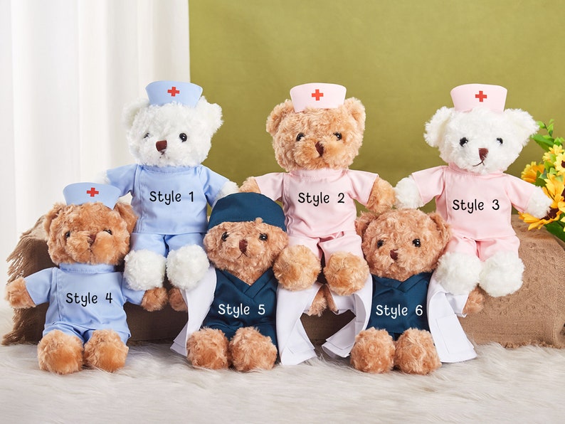 May include: Six plush teddy bears dressed as nurses in different styles. The bears are wearing blue, pink, and white uniforms with red crosses. The bears are sitting on a brown surface.