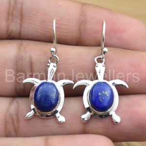 Può includere: Orecchini in argento sterling con una pietra preziosa in lapislazzuli blu incastonata in un design a forma di tartaruga.