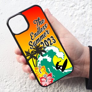May include: A black phone case with a colourful design featuring palm trees, a wave, a surfer, and the text "The Endless Summer 2023".