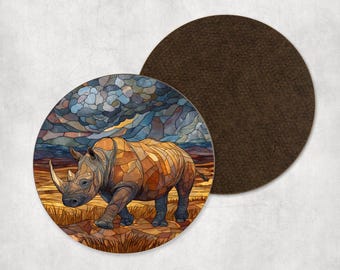 Op de afbeelding: Een ronde onderzetter met een mozaïekachtige illustratie van een neushoorn die door een savannelandschap loopt onder een stormachtige lucht. De onderzetter heeft een bruine, lederachtige achterkant.