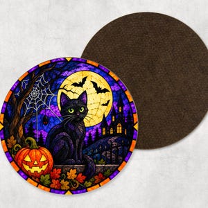 May include: A round coaster featuring a stained glass style illustration of a black cat sitting next to a jack-o'-lantern, a spider web, a full moon, bats, and a dark house silhouette, with a solid dark brown circular backing visible behind it.