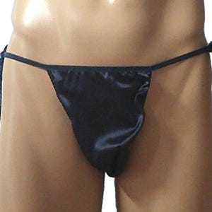 May include: A dark navy blue satin thong featuring a triangular front panel and thin side ties that are knotted at the hips. The fabric has a smooth, reflective finish and the design consists of a minimalist cut with adjustable side strings.