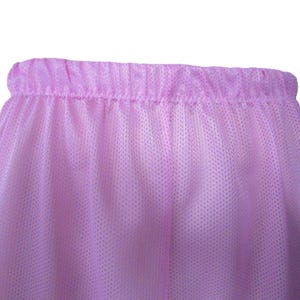 Könnte beinhalten: Nahaufnahme einer hellvioletten Mesh-Shorts. Die Shorts haben einen elastischen Bund und ein lockeres, fließendes Design. Der Stoff hat eine gepunktete Textur.