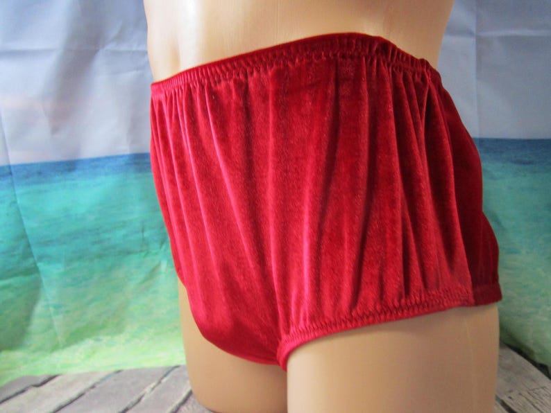 Puede incluir: Primer plano de ropa interior de terciopelo rojo. La cintura el&aacute;stica es visible y la tela tiene un aspecto suave y texturizado. La ropa interior es de color rojo vivo liso.