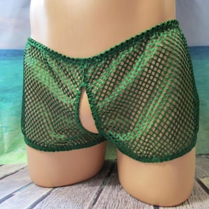 May include: Green mesh shorts with an open design. The shorts are made of a net-like material and are displayed on a mannequin. The shorts are a vibrant green color and have a unique, open-front design.