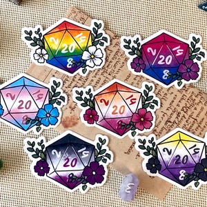 Può includere: Set di sei adesivi colorati di dadi D20, ognuno con un diverso design della bandiera del Pride LGBTQ+. I dadi sono decorati con elementi floreali e il numero 20. Per gli appassionati di giochi da tavolo.