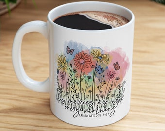 May include: White ceramic coffee mug with a watercolor design of flowers and butterflies. The text "His mercies are new every morning" and "Lamentations 3:23" are printed on the mug.