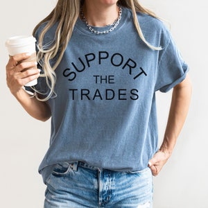 May include: A blue t-shirt with the text "SUPPORT THE TRADES" in black lettering.