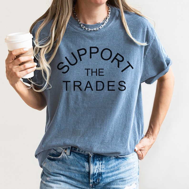 May include: A blue t-shirt with the text "SUPPORT THE TRADES" in black lettering.