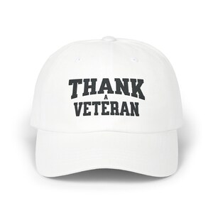 Puede incluir: Gorra de béisbol blanca con texto bordado en negro que dice "THANK A VETERAN".