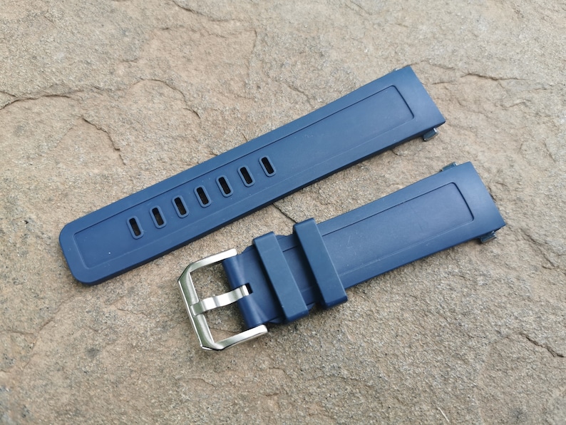 Pu&ograve; includere: Due cinturini per orologio in silicone blu con fibbia argentata. I cinturini sono piatti e hanno una texture liscia.