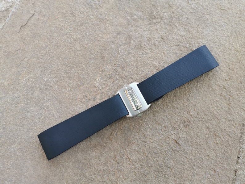 Puede incluir: Un cintur&oacute;n negro con una hebilla de metal plateado. El cintur&oacute;n est&aacute; hecho de un material liso y duradero y est&aacute; dise&ntilde;ado para usarse alrededor de la cintura. La hebilla tiene un dise&ntilde;o rectangular simple.