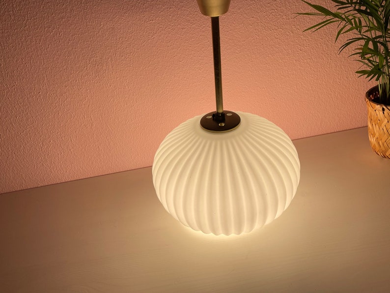 May include: A white, ribbed glass pendant light fixture with a gold metal stem.