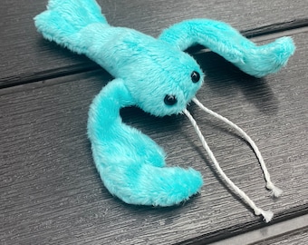 May include: A turquoise blue plush lobster toy with white string antennae. The lobster has black eyes and is made of soft, fuzzy fabric.
