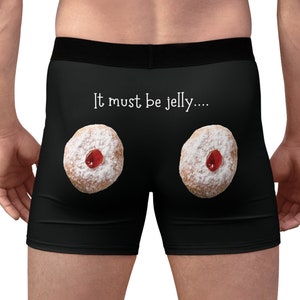 May include: Black boxer shorts with the text "It must be jelly...." in white. The shorts display two illustrations of jam-filled doughnuts, dusted with icing sugar and a cherry centre.