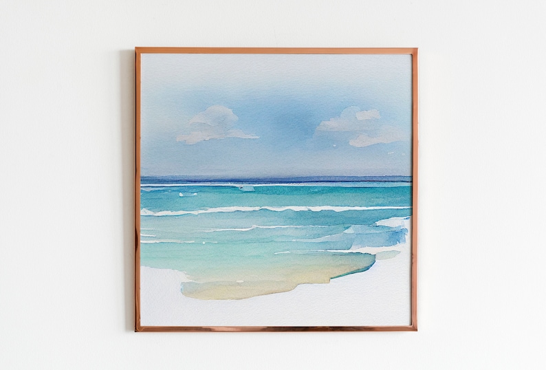 Puede incluir: Pintura de acuarela enmarcada de una escena de playa. La obra representa un oc&eacute;ano sereno con tonos turquesa y azul, un cielo azul claro y dos peque&ntilde;as nubes. El marco es de color cobre, lo que se suma a la est&eacute;tica.