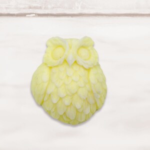 May include: A yellow owl-shaped soap bar with detailed feathers and eyes.