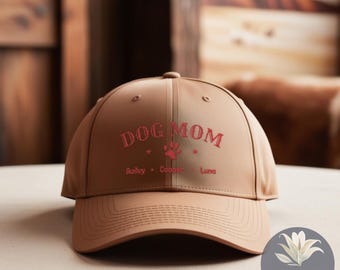 May include: A brown baseball cap with the text "Dog Mom" embroidered in red. The names Bailey, Cooper, and Luna are also embroidered in red below the text.