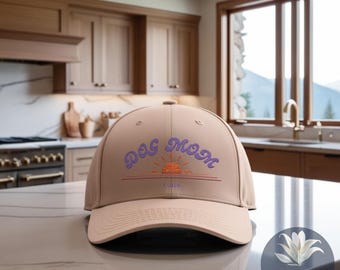 May include: A tan baseball cap with a purple and orange embroidered design that says "Dog Mom" with a sunset graphic and the word "Luna" underneath.