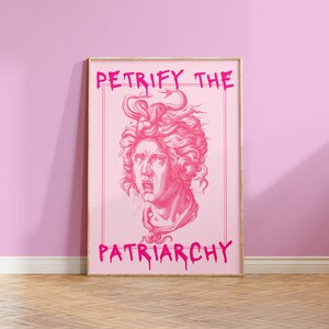 May include: Pink framed poster featuring a pink illustration of Medusa's head with snakes for hair. The text "Petrify the Patriarchy" is written in pink dripping letters.