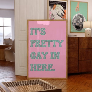 May include: A pink and green poster with the text "IT'S PRETTY GAY IN HERE." in a retro font.