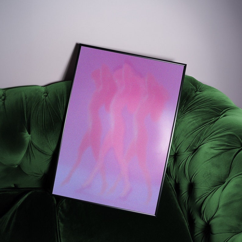 May include: A framed print with a pink and purple gradient background featuring three abstract figures in silhouette.