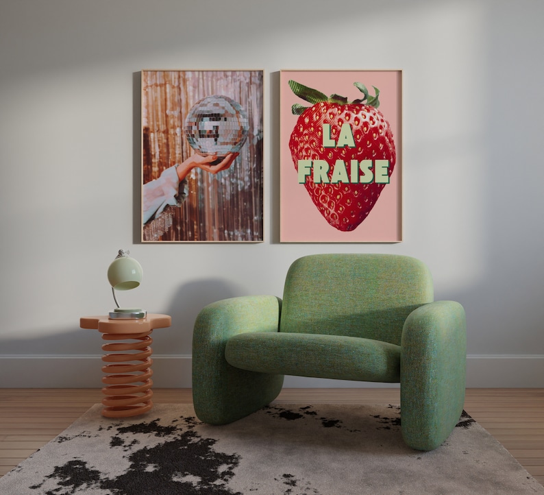 K&ouml;nnte beinhalten: Zwei gerahmte Drucke h&auml;ngen an einer wei&szlig;en Wand. Der Druck links zeigt eine Hand, die eine Discokugel h&auml;lt. Der Druck rechts zeigt eine rote Erdbeere mit dem Text "LA FRAISE" in gr&uuml;nen Buchstaben.