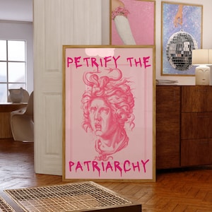 May include: Pink framed poster with a pink background and a black and white illustration of a woman's head with snakes in her hair. The text "PETRIFY THE PATRIARCHY" is written in pink dripping letters.